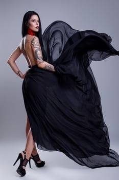 Portrait of woman with tattoos wearing black dress photo