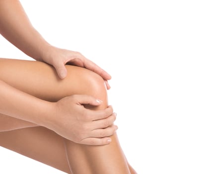 Woman with pain in her knee against white background photo