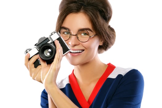 Woman model in vintage look holding retro camera in her hands photo