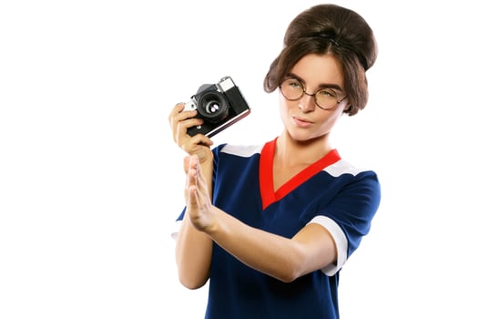 Woman model in vintage look holding retro camera in her hands photo
