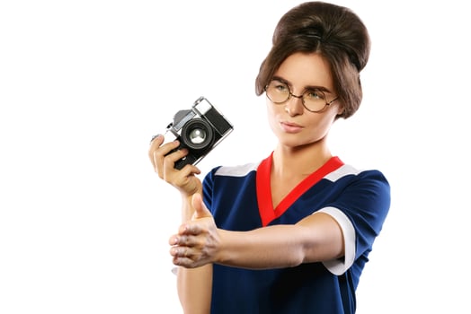 Woman model in vintage look holding retro camera in her hands photo