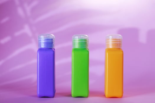 Isolated spa cosmetic products, multicolored tubes on a pink background. photo
