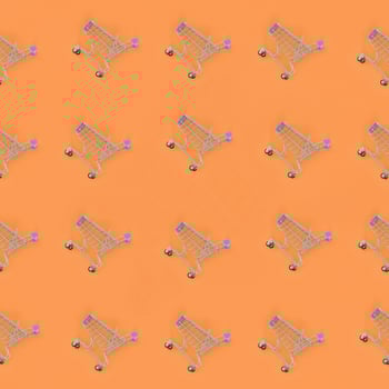 Shopping addiction, shopping lover or shopaholic concept. Many small empty shopping carts perform a pattern on a pastel colored paper background. Flat lay composition, top view photo