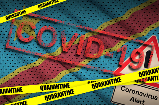 Democratic Republic of the Congo flag and Covid-19 quarantine yellow tape with red stamp. Coronavirus or 2019-nCov virus photo