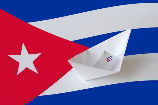Cuba flag depicted on paper origami ship closeup. Handmade arts concept photo