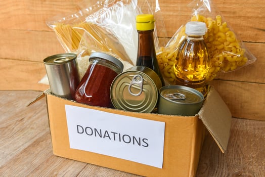 Donations box with canned food on wooden table background  pasta canned goods and dry food non perishable with cooking oil rice noodles spaghetti macaroni donations food photo