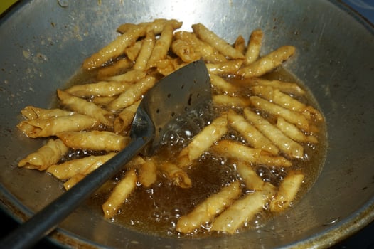 The process of making or cooking an kacang sembunyi , Popular snack from indonesia. Beans wrapped in a dough skin from flour . Deep fried using oil and  liquid sugar. photo