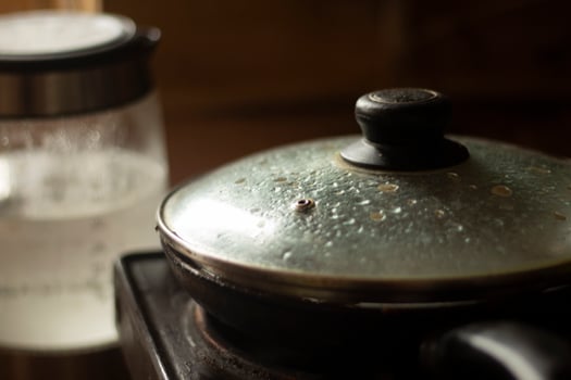 Frying pan with lid in kitchen. Frying pan with swollen glass. Interior of kitchen. photo