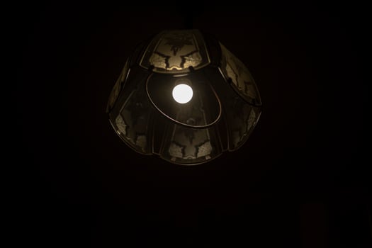 Lamp in dark. Chandelier with one lamp. Light source. photo