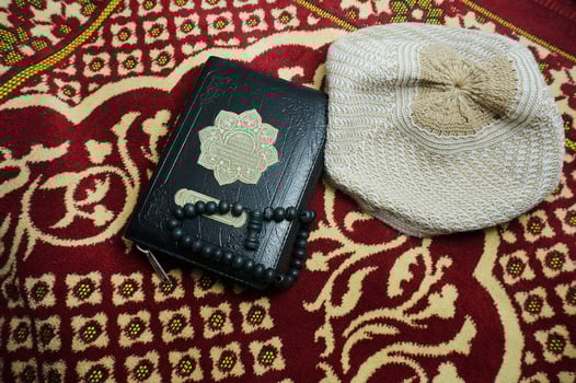 Al Quran With Indonesia Translate on a prayer mat. Quran is an Islamic holy book for muslim. photo