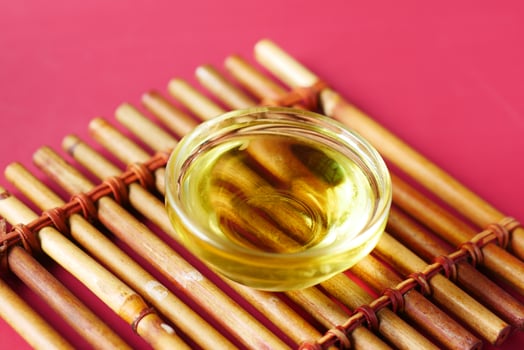 bottle of olive oil and olive leaves on yellow photo