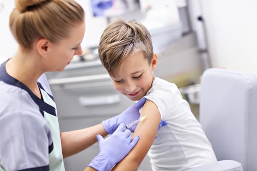 Brave little boy receiving injection or vaccine with a smile photo