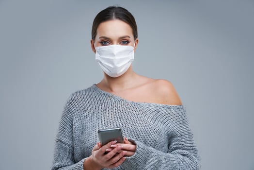 Portrait of beautiful woman in mask on gray background photo