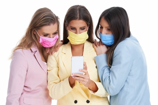 Three women in pastel suits posing with smartphones over white background photo