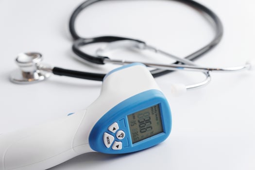 Close up of digital infrared thermometer and stethoscope photo