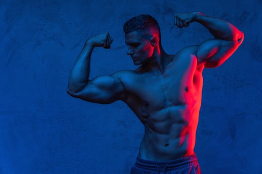 Muscular man posing in the colorful light photo