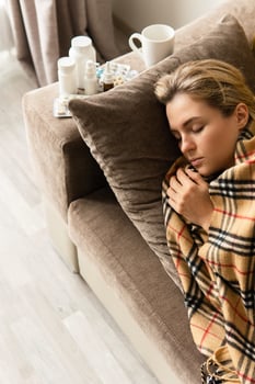 Sick woman is sleeping under the blanket at home photo