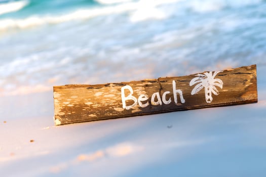 Wooden sign with lettering on the beach photo