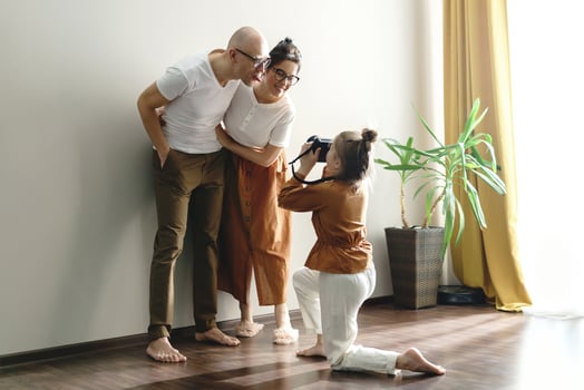 Little daughter taking picture of her parents photo