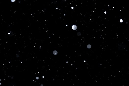 Element for winter design or overlay. Real snow over black background. photo