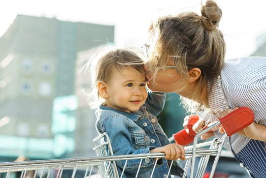 Young beautiful mother and her cute little son in a shopping cart photo