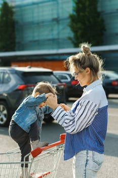 Young mother and her cute little son are having fun with shopping cart photo