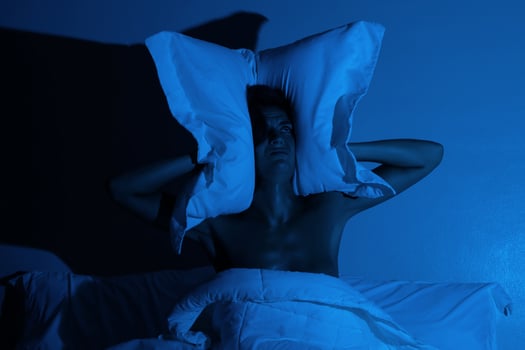 Woman in the bedroom with a pillow on her head photo