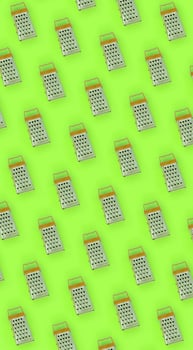 Small stainless steel graters lies on a pastel colored paper. Kitchen accessories. Tools for cooking. Flat lay top view photo