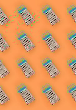 Small stainless steel graters lies on a pastel colored paper. Kitchen accessories. Tools for cooking. Flat lay top view photo