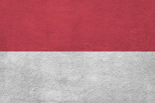 Indonesia flag depicted in bright paint colors on old relief plastering wall. Textured banner on rough background photo