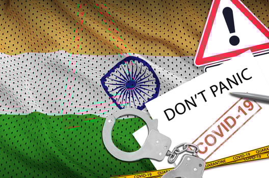 India flag and police handcuffs with inscription Don't panic on white paper. Coronavirus or 2019-nCov virus concept photo