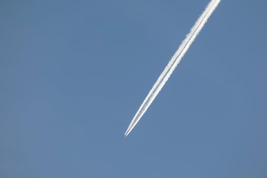 white wake of an airplane under the blue sky photo