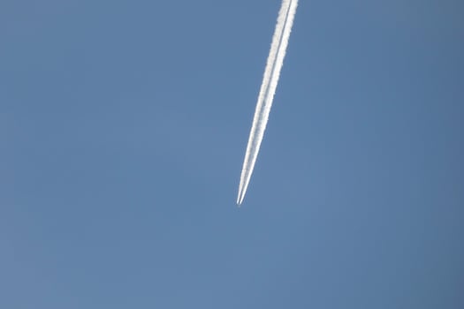 white wake of an airplane under the blue sky photo