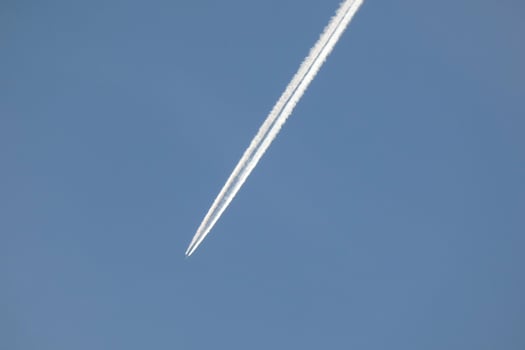 white wake of an airplane under the blue sky photo