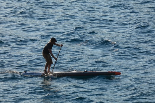 swimmer on vacation paddle surfing in the mediterranean sea photo