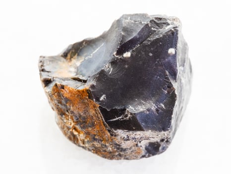 raw black Flint stone on white marble photo