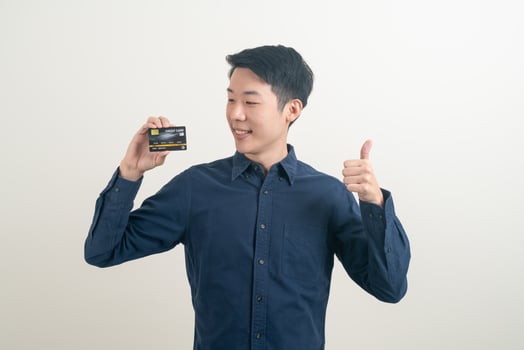 young Asian man holding credit card photo