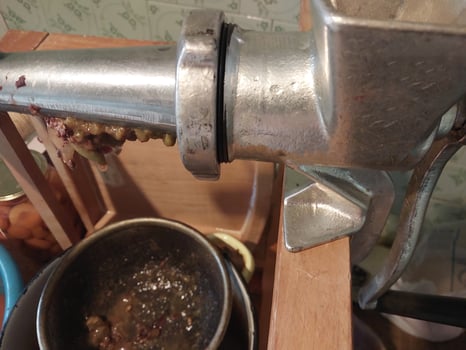 Squeezing grape juice with a screw manual meat grinder photo