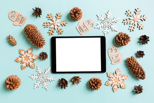 Top view of digital tablet, holiday toys and decorations on blue Christmas background. New Year time concept photo