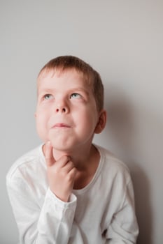 Portrait of an emotional child. The boy was thinking about something. Facial expression. Thinking child photo