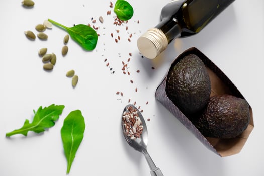 olive oil, avocado, spinach, arugula and sesame seeds on a white plate. Still life of healthy food. Composition of products for avocado salad. photo