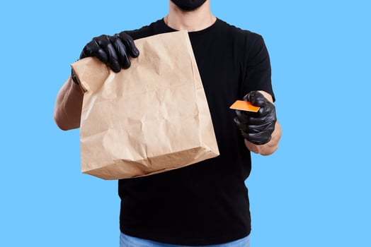 Delivery man hold paper bag with food. Food delivery concept photo