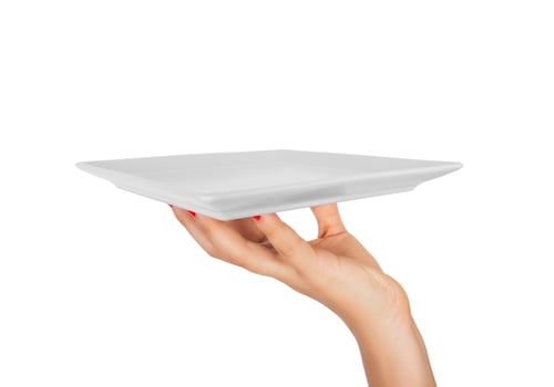 Blank white square matte plate in female hand. perspective view, isolated on white background photo