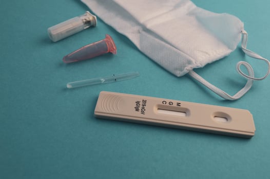 antibody test. self-diagnosis strip for coronavirus infection on a blue matte background. next to the test, a disposable mask and a needle for piercing a finger. home infection detection kit photo
