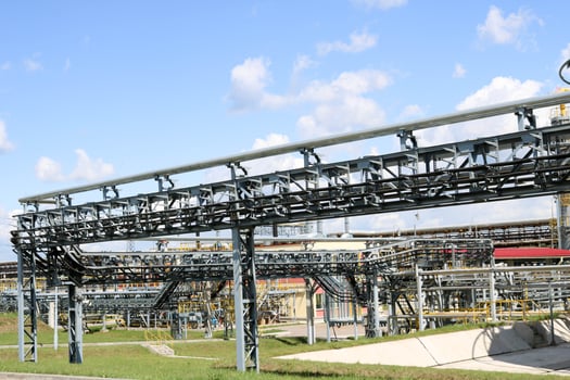 A large iron metal piping trestle with pipes and electric wires and equipment at the petrochemical refinery industrial refinery photo