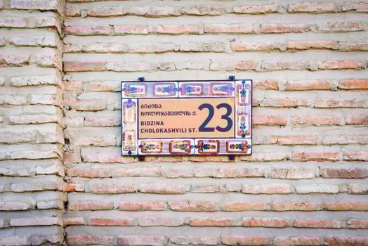 Brick wall with stylish ornamental house number and street name sign in old town Telavi. Bidzina Cholokashvili street of historical old houses.Georgian Heritage site in Kakheti photo