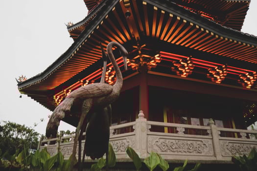 A Pagoda in the center of a Chinatown with a brown stork statue. photo