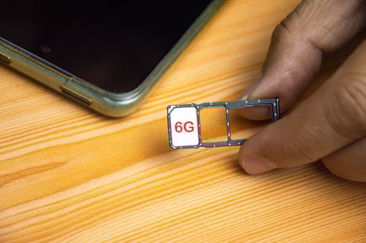 6G technology, Internet concept. SIM card in smartphone tray on wooden table, closeup 6G network concept, high speed mobile internet New age network, business concept photo