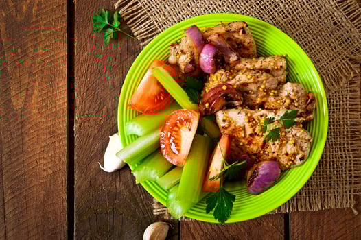 Sliced pork grilled with vegetables on ceramic brown plate. photo