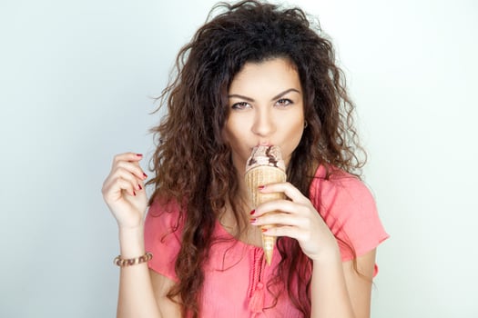 serious young woman eats ice cream cone photo